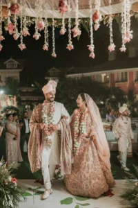 Bride and groom walking together after ceremony with garlands